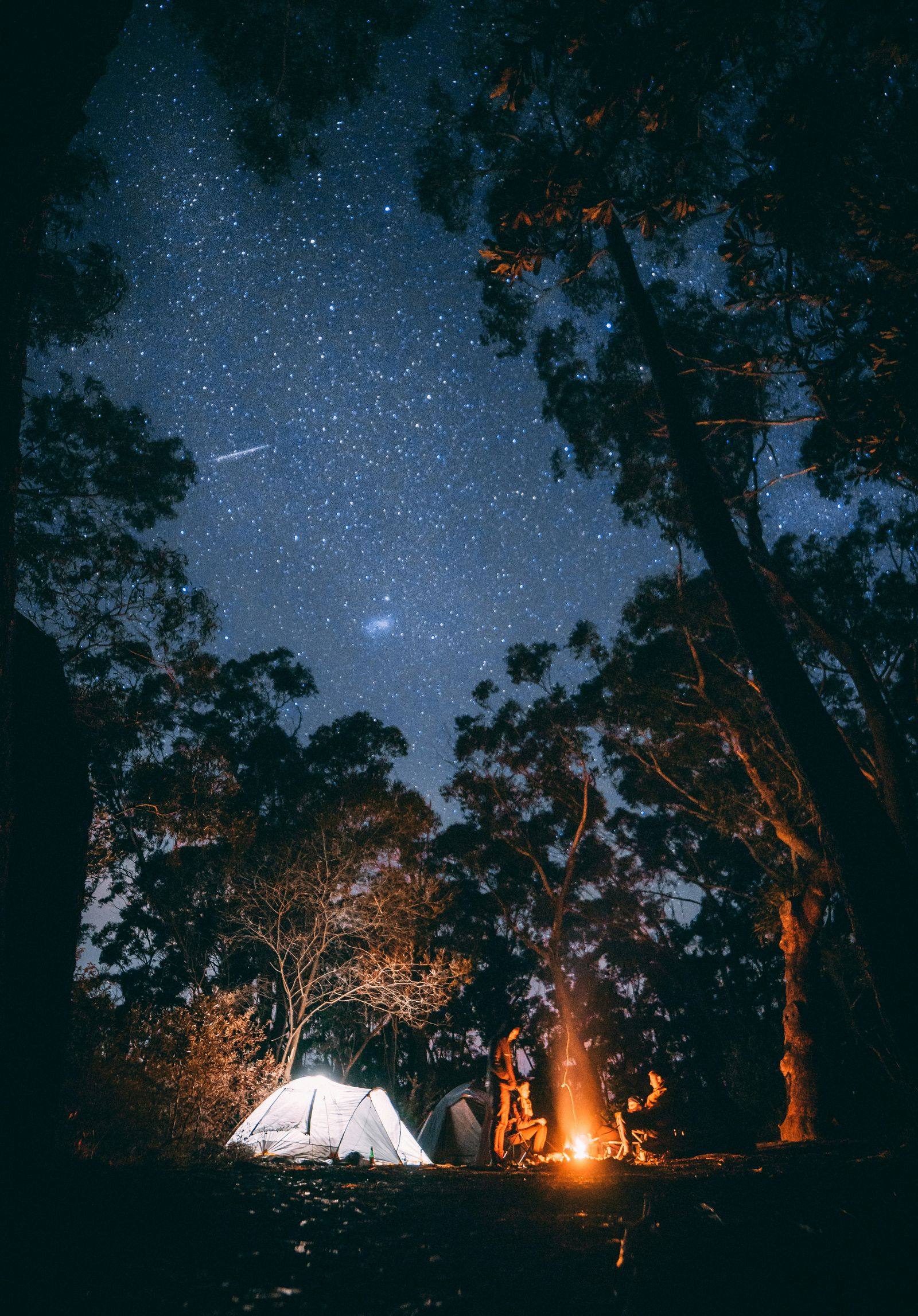 Bivouac éclairé sous un ciel étoilé, univers des voyages en couple et lunes de miel