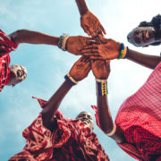 Masai in traditional clothes joining hands in unity (Zanzibar, Tanzania),