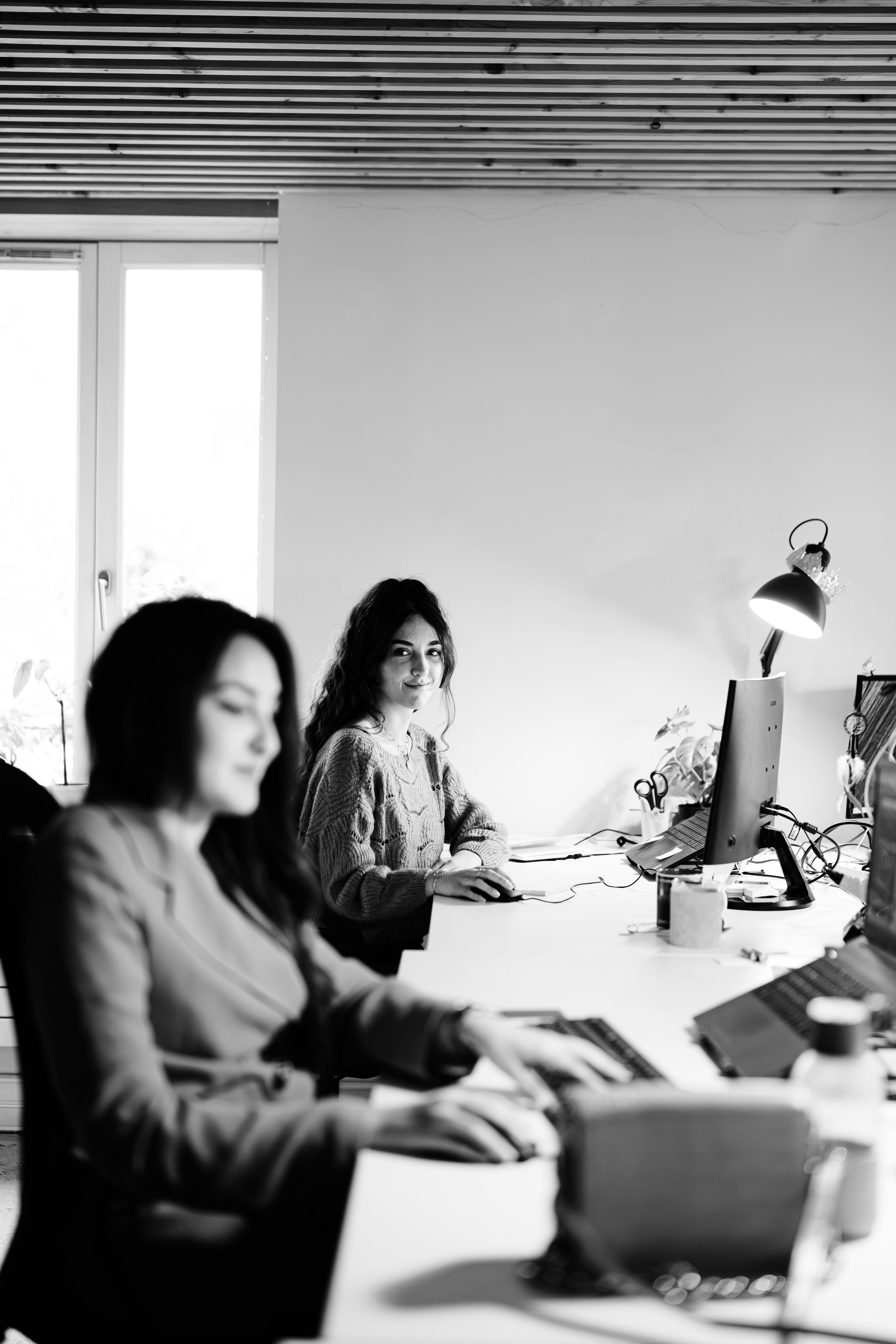 Plateau de l'agence Travel-Insight, équipes au travail en noir et blanc