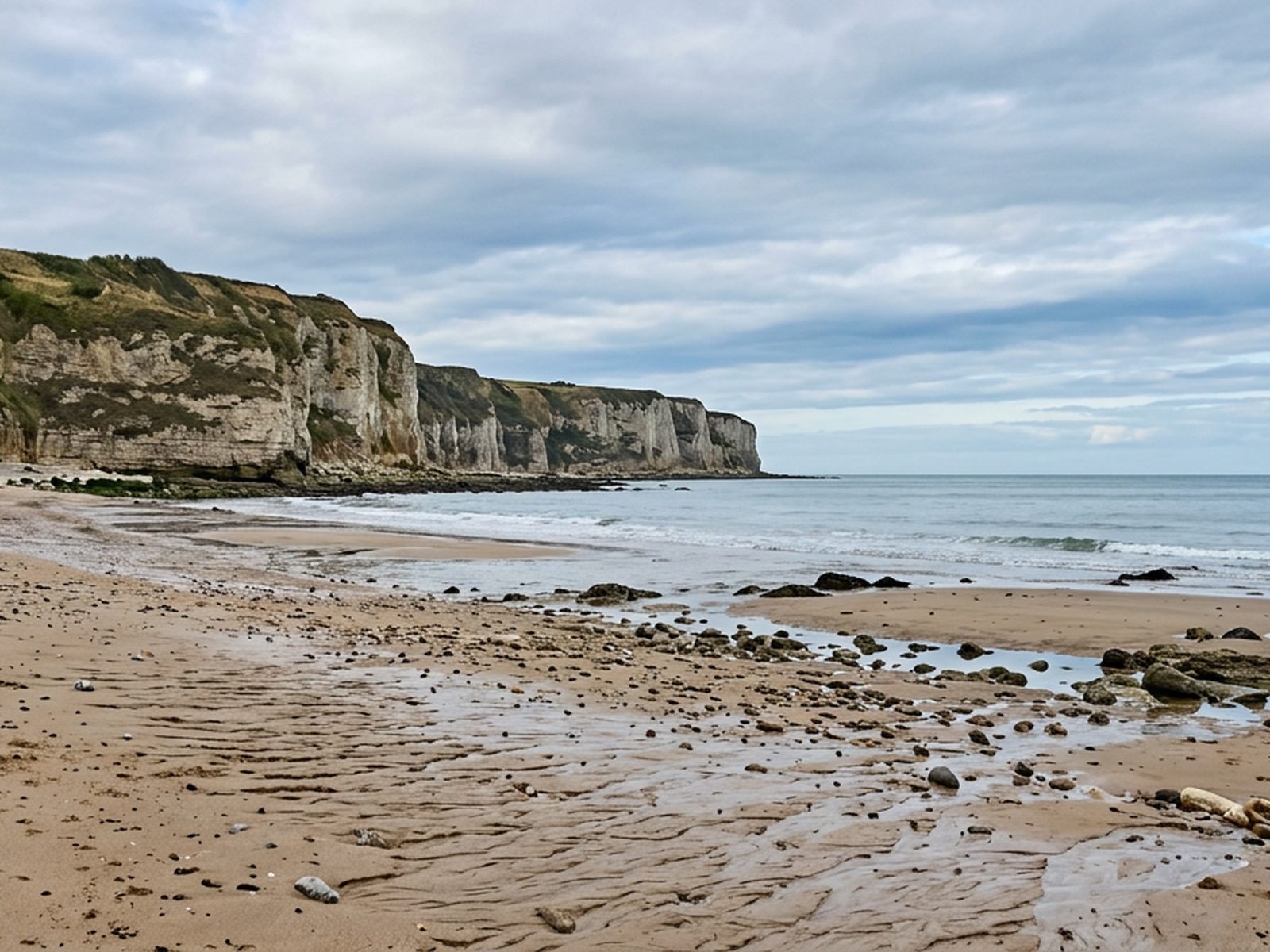 Calvados : plage du Calvados à marée basse, falaise et ciel normand — illustration de la zone d'intervention de Travel-Insight